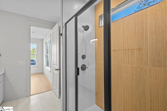 bathroom with wood-type flooring, vanity, and walk in shower