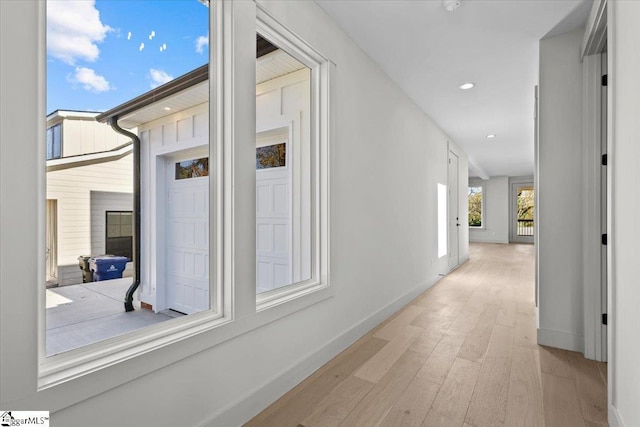 hallway with baseboards, wood finished floors, and recessed lighting