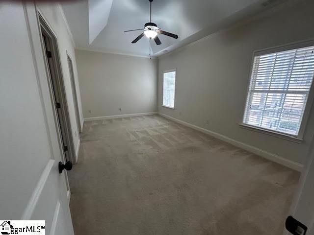 unfurnished bedroom with carpet floors, crown molding, ceiling fan, and baseboards