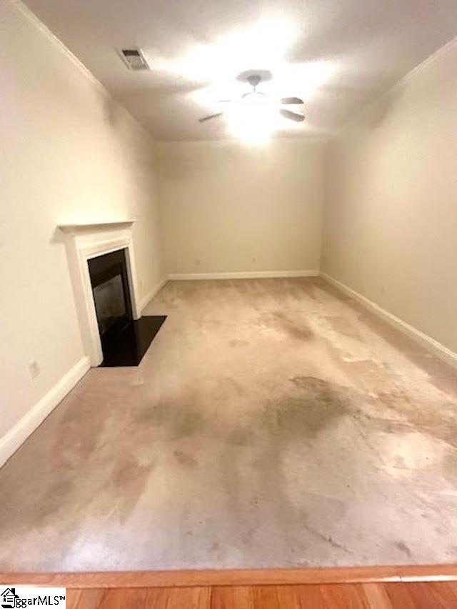 below grade area featuring a fireplace with flush hearth, visible vents, and baseboards