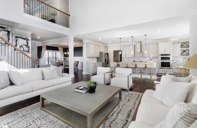 living room with a high ceiling, dark hardwood / wood-style flooring, and ornamental molding