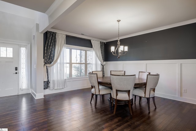 dining room featuring crown molding, dark hardwood / wood-style floors, and an inviting chandelier