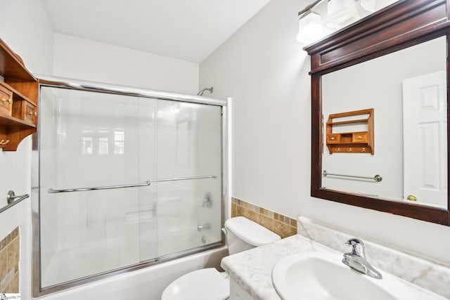 full bathroom featuring vanity, toilet, and enclosed tub / shower combo