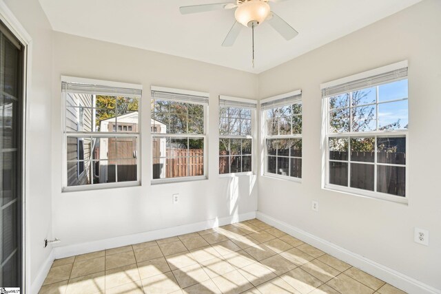 unfurnished sunroom with ceiling fan