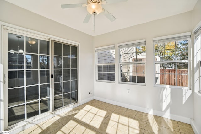 unfurnished sunroom with ceiling fan