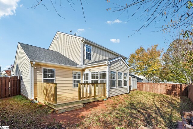 rear view of house featuring a yard and a deck