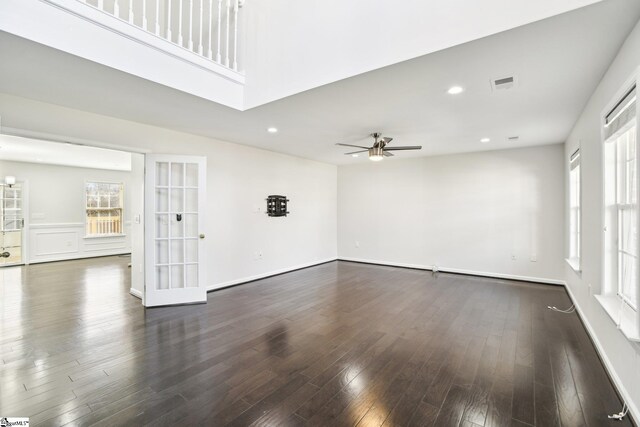 unfurnished living room featuring ceiling fan, french doors, and dark wood-type flooring