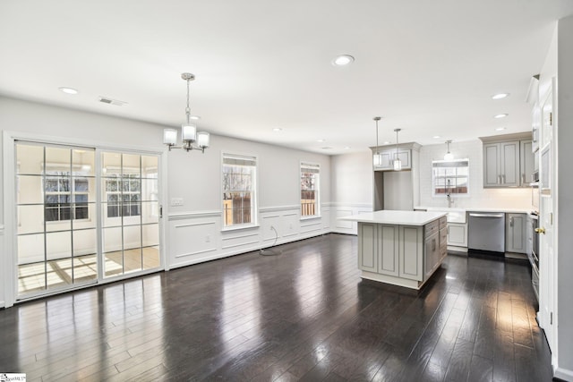 kitchen featuring stainless steel appliances, dark hardwood / wood-style flooring, a center island, and pendant lighting