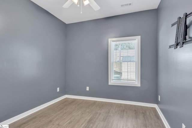 empty room with ceiling fan and light hardwood / wood-style flooring