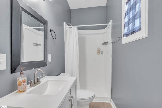 bathroom featuring vanity, toilet, and walk in shower