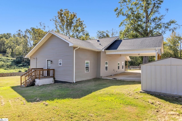 rear view of property featuring a patio, a shed, and a lawn