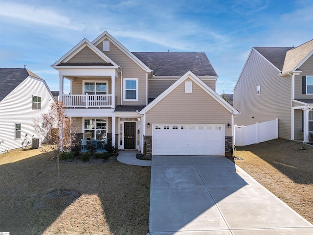 craftsman house with a balcony, a front lawn, central AC unit, covered porch, and a garage