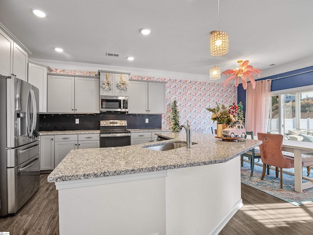 kitchen with sink, hanging light fixtures, dark hardwood / wood-style flooring, appliances with stainless steel finishes, and ornamental molding