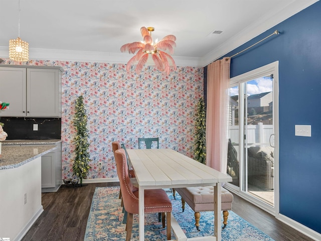 dining area featuring a chandelier, ornamental molding, and dark wood-type flooring