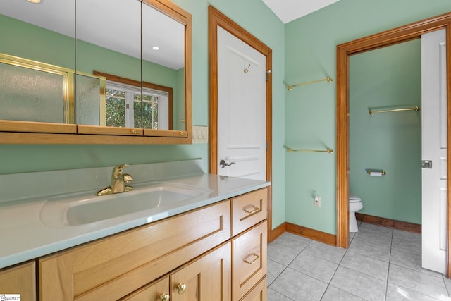 bathroom with tile patterned floors, vanity, toilet, and a shower with shower door