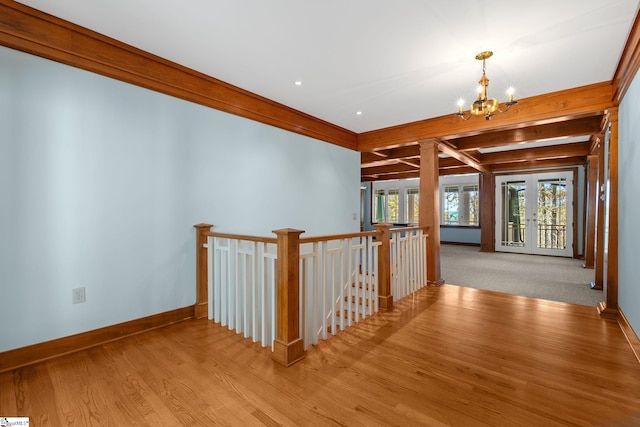 hallway with french doors, beamed ceiling, light hardwood / wood-style floors, and an inviting chandelier