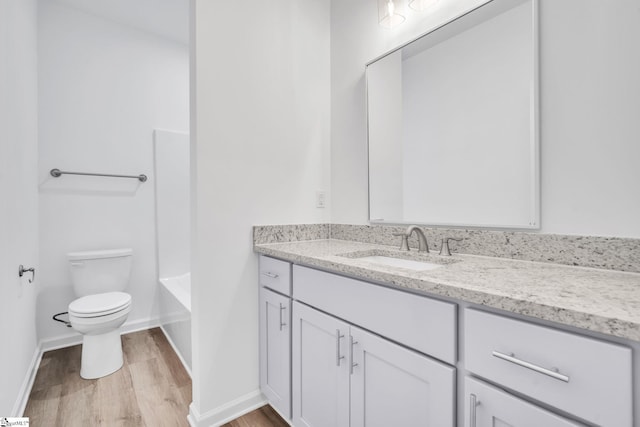 full bathroom featuring hardwood / wood-style floors, vanity,  shower combination, and toilet