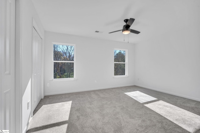 spare room featuring ceiling fan and light colored carpet