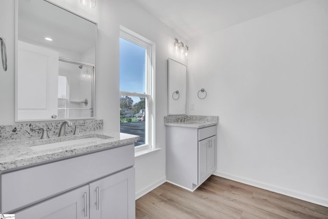 bathroom featuring vanity, wood-type flooring, and walk in shower