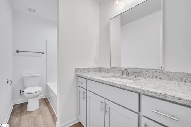 full bathroom featuring hardwood / wood-style floors, vanity,  shower combination, and toilet