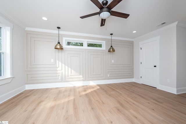 unfurnished living room with a wealth of natural light, light hardwood / wood-style floors, and ornamental molding