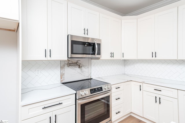 kitchen with light stone countertops, stainless steel appliances, white cabinetry, and tasteful backsplash