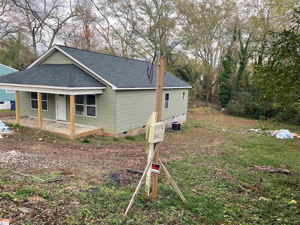 view of side of home featuring central air condition unit and covered porch