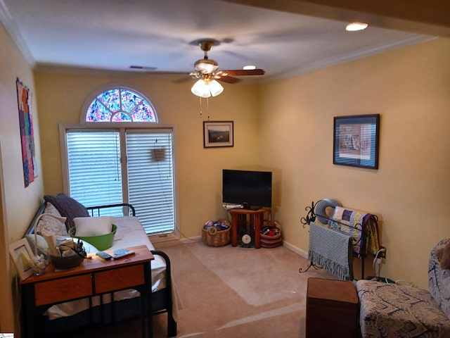 living room featuring visible vents, crown molding, baseboards, carpet flooring, and a ceiling fan