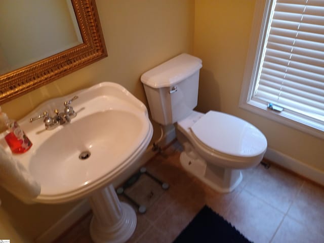 bathroom with tile patterned floors, toilet, and baseboards