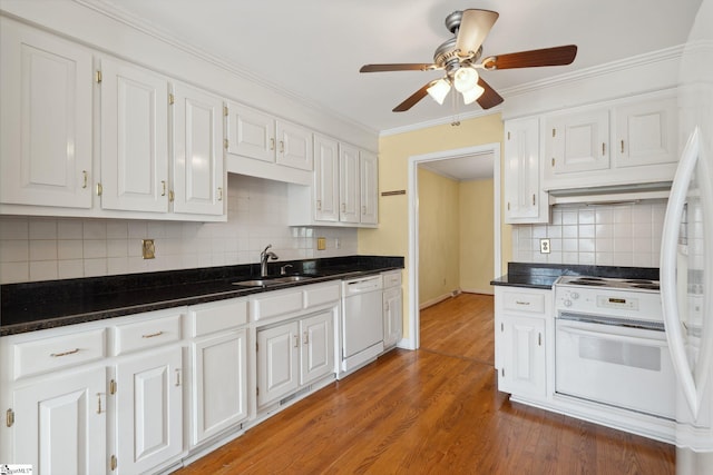 kitchen with ornamental molding, wood finished floors, white appliances, white cabinetry, and a sink