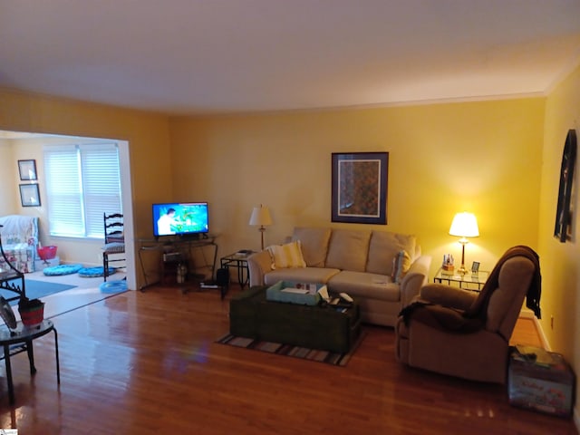 living room with hardwood / wood-style flooring and ornamental molding