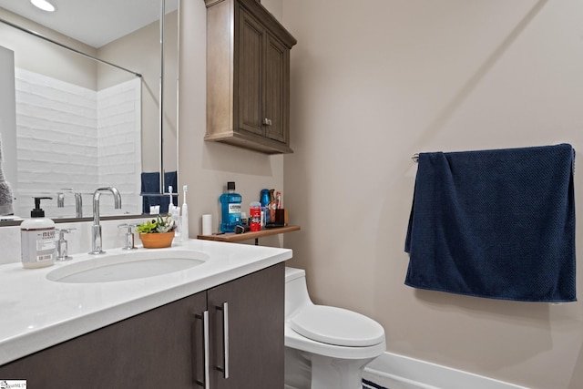 bathroom with toilet, vanity, and walk in shower