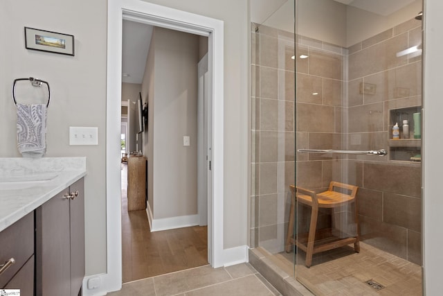 bathroom with vanity, a shower with shower door, and wood-type flooring