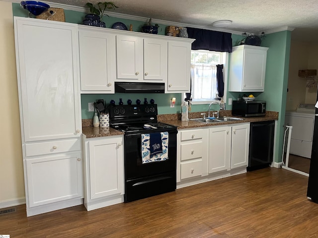 kitchen with a textured ceiling, ventilation hood, black appliances, washer / clothes dryer, and white cabinetry