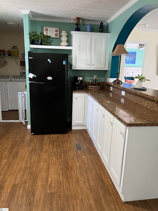 kitchen featuring washer and clothes dryer, dark stone counters, white cabinets, a textured ceiling, and dark hardwood / wood-style flooring