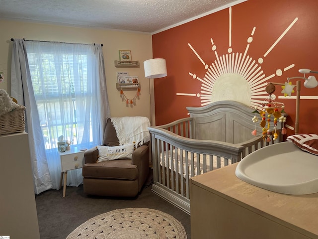 carpeted bedroom featuring a crib and a textured ceiling