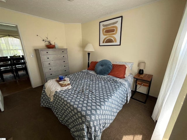 bedroom with dark colored carpet and a textured ceiling