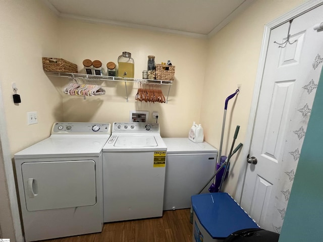 washroom featuring dark wood-type flooring, ornamental molding, and washing machine and clothes dryer