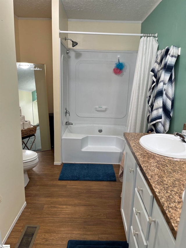 full bathroom featuring hardwood / wood-style floors, vanity, a textured ceiling, and toilet