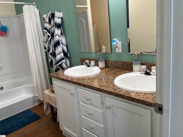 bathroom featuring hardwood / wood-style floors, vanity, and shower / bathtub combination with curtain