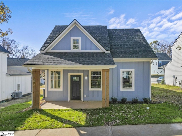 view of front of home with central AC and a front lawn