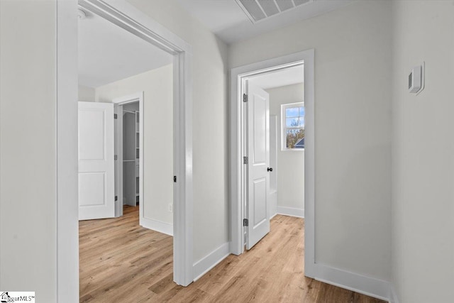 corridor with light hardwood / wood-style floors