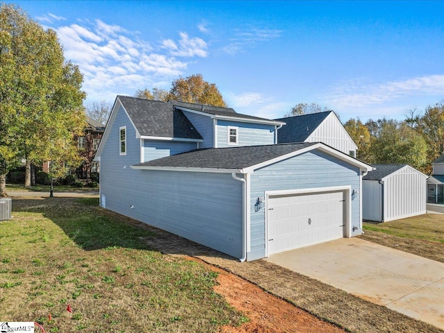 view of front of property featuring a garage, central air condition unit, and a front yard