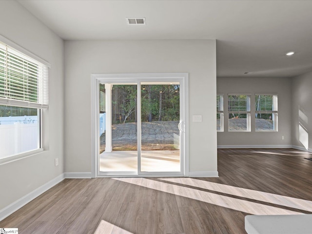 unfurnished room featuring a wealth of natural light and hardwood / wood-style flooring