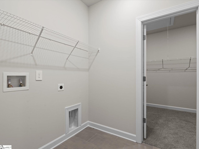 washroom featuring electric dryer hookup, dark tile patterned floors, and washer hookup