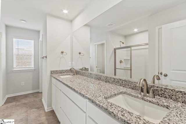 bathroom featuring vanity, toilet, and a shower with door