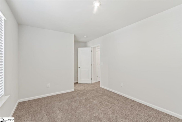 unfurnished room featuring light colored carpet