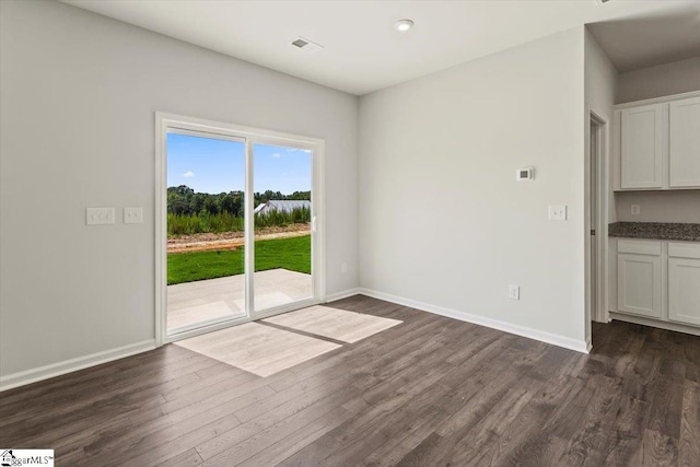 unfurnished dining area featuring dark wood-type flooring