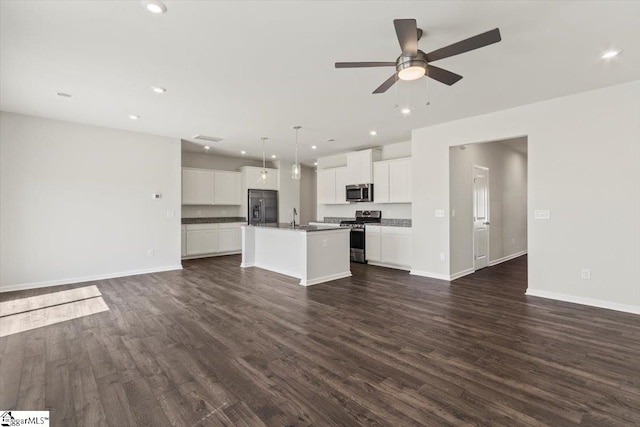 unfurnished living room featuring dark hardwood / wood-style flooring, ceiling fan, and sink