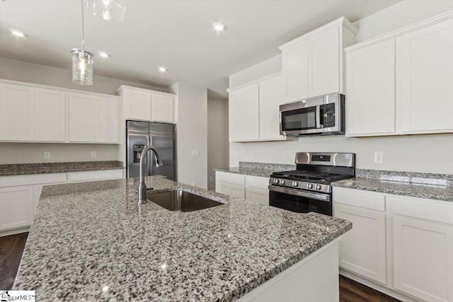 kitchen with sink, dark wood-type flooring, stainless steel appliances, a kitchen island with sink, and white cabinets